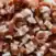 Close-up of diced raw bacon pieces, showing layers of pink meat and white fat.