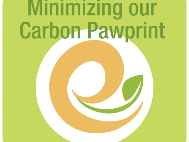 A green and orange logo with a leaf and the text "Minimizing our Carbon Pawprint" on a light green background.