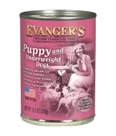 A case of 12 cans of Heritage Classic Puppy Food, 12.5 oz each, with a pink label featuring a woman and puppies plus nutrition details.