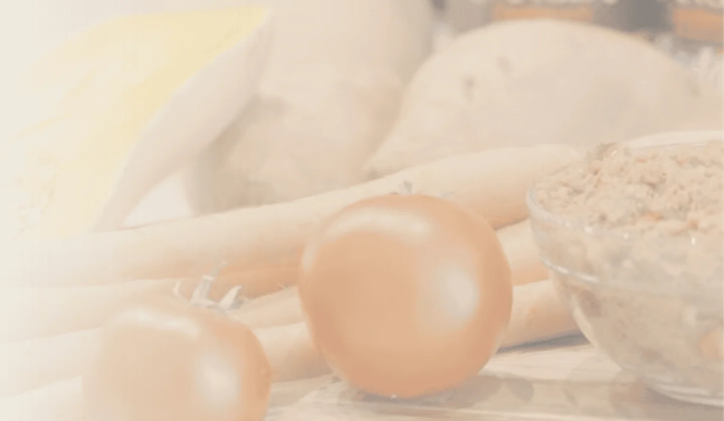 Assorted vegetables including tomatoes, carrots, sweet potatoes, and squash placed near a bowl of spread and canned goods on a kitchen surface.