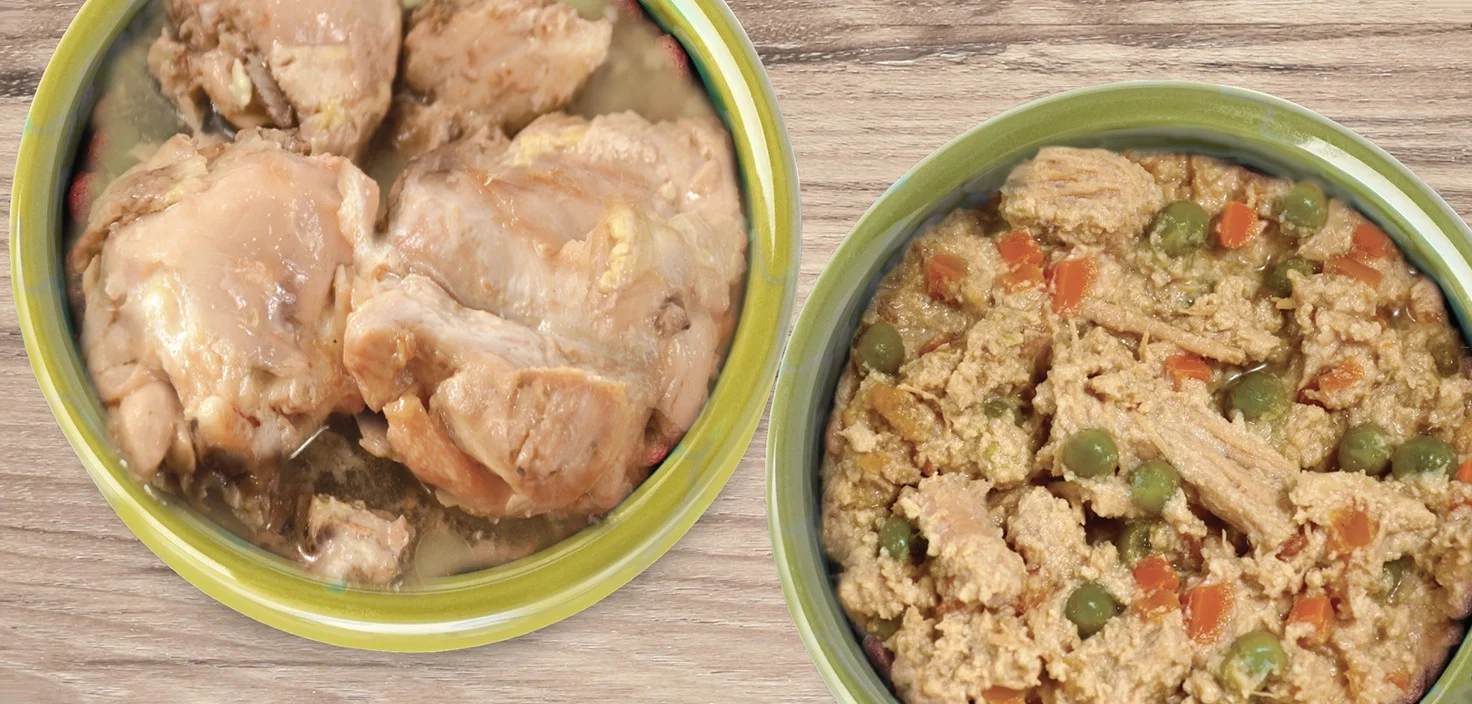 Two bowls of food on a wooden surface; the left bowl contains pieces of cooked chicken, while the right bowl contains a stew with vegetables and textured protein chunks.